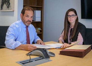 Attorneys Steve Kantor and Christina Gullo sitting at a conference table reviewing a document