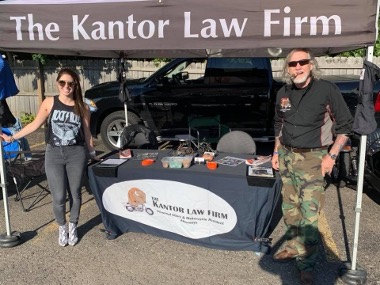 Attorney Christina Gullo stands near Paul "Flyboy" Fedorsak under the Kantor Law Firm canopy at a local biker event