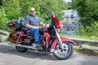 Marketing guy, Chris Genovese, sits on his 2017 Harley Davidson Ultra Limited in front of Glen Falls in the Village of Williamsville, NY