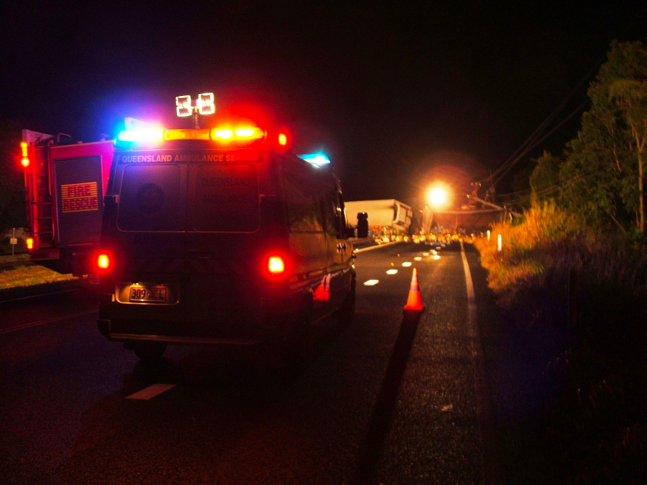 An ambulance and a fire rescue truck with flashing lights parked at the scene of a traffic incident