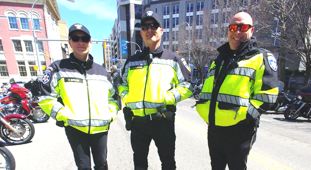 Three police officers standing on Pearl Street in downtown Buffalo, NY before they begin their duties as the outriders and escorts for the ABATE of Buffalo/Erie Awareness Run, May 15, 2023