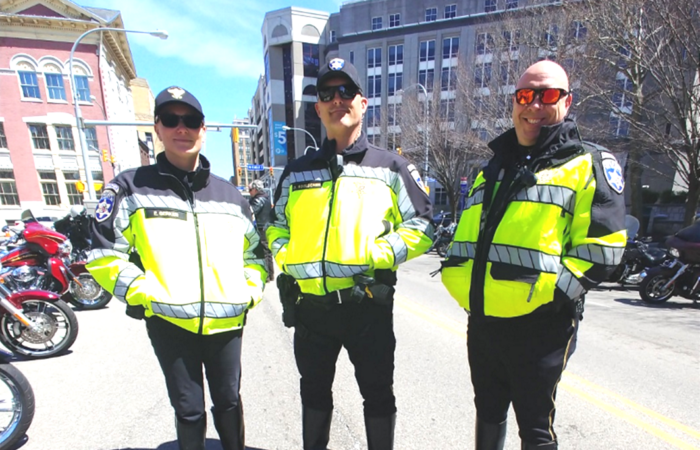 Three police officers standing on Pearl Street in downtown Buffalo, NY before they begin their duties as the outriders and escorts for the ABATE of Buffalo/Erie Awareness Run, May 15, 2023