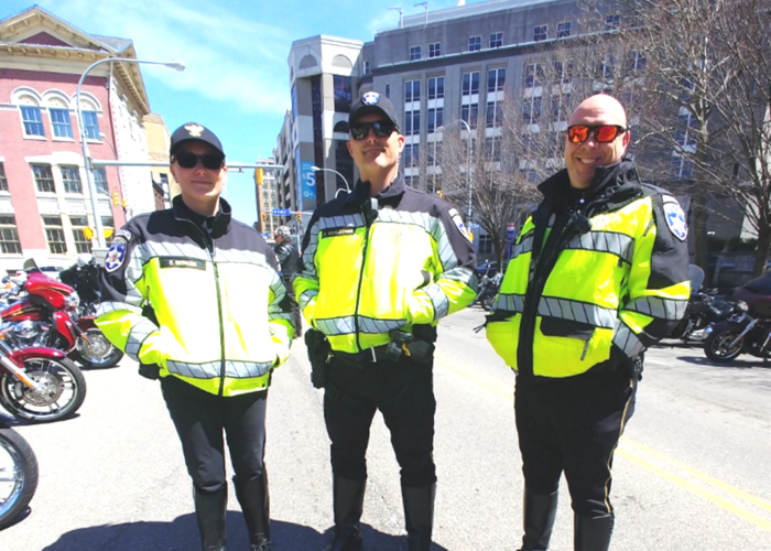 Three police officers standing on Pearl Street in downtown Buffalo, NY before they begin their duties as the outriders and escorts for the ABATE of Buffalo/Erie Awareness Run, May 15, 2023