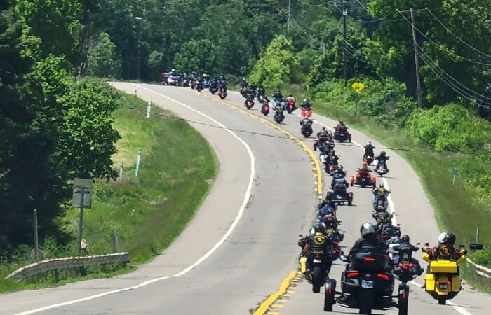 Motorcycle riders and members of the Combat Vets Motorcycle Association move together down the road in staggered formation to raise awareness for Veteran Suicide.