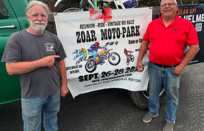 John Watson and Ed Abdo stand in front of a banner promoting the Zoar Moto-Park Reunion to be held September 26 - 28, 2025