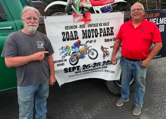 John Watson and Ed Abdo stand in front of a banner promoting the Zoar Moto-Park Reunion to be held September 26 - 28, 2025