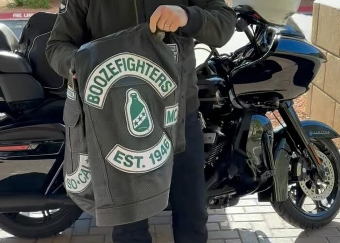 Robert Patrick stands in front of his Harley Davidson Road Glide motorcycle and shows off his perforated Boozefighters vest