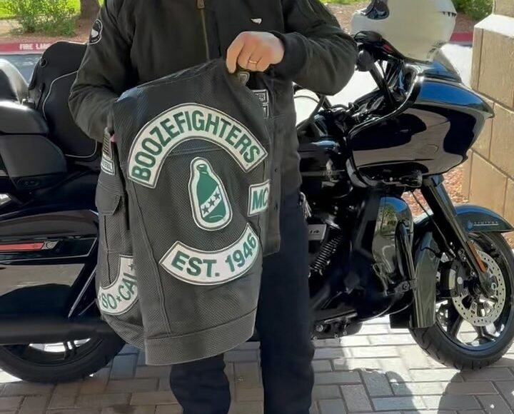 Robert Patrick stands in front of his Harley Davidson Road Glide motorcycle and shows off his perforated Boozefighters vest
