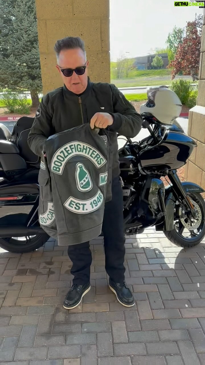 Robert Patrick stands in front of his Harley Davidson Road Glide motorcycle and shows off his perforated Boozefighters vest