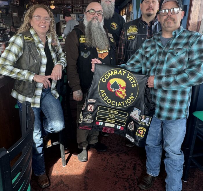 Members of Combat Veterans Motorcycle Association 19-11 pose and display their patches on the back of a member's leather riding vest.