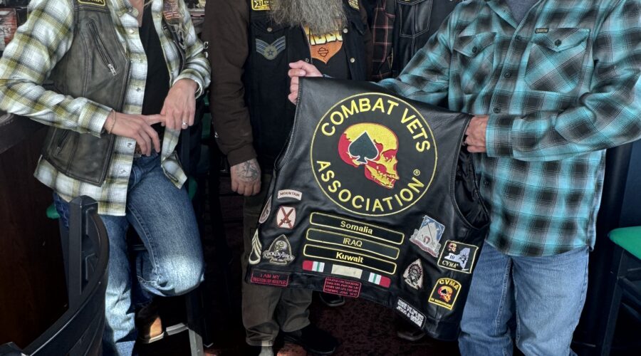 IMG_6384 Members of Combat Veterans Motorcycle Association 19-11 pose and display their patches on the back of a member's leather riding vest.