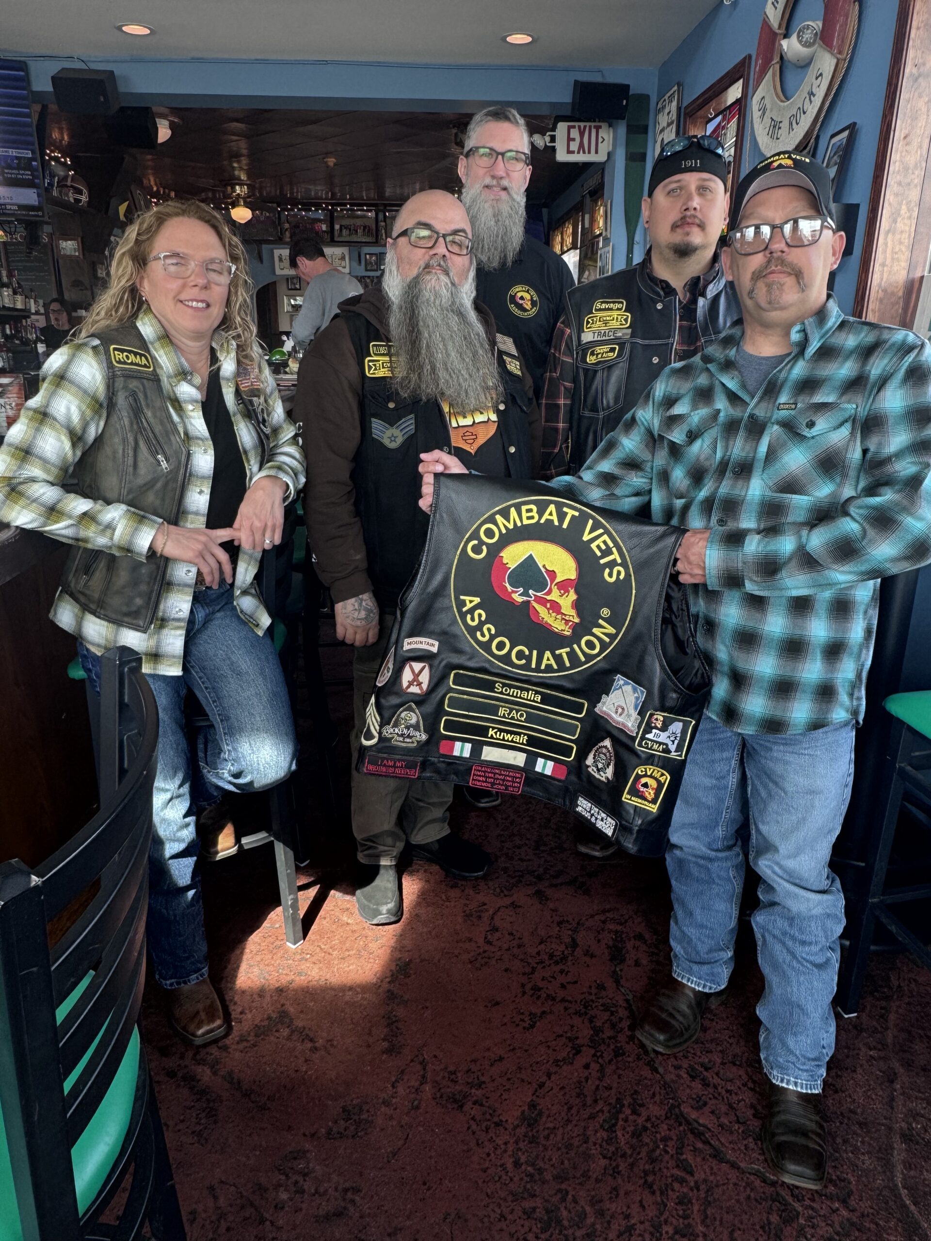 IMG_6384 Members of Combat Veterans Motorcycle Association 19-11 pose and display their patches on the back of a member's leather riding vest.