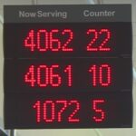 maxresdefault An illuminated "now serving" sign with red lights showing an array of large numbers beneath "now serving" and another array of smaller numbers below "counter." The numbers indicate a large volume of customers and counters where they could be served, most likely indicating a long wait for service.