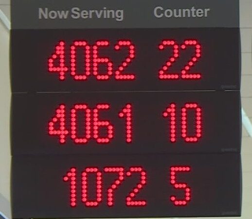 maxresdefault An illuminated "now serving" sign with red lights showing an array of large numbers beneath "now serving" and another array of smaller numbers below "counter." The numbers indicate a large volume of customers and counters where they could be served, most likely indicating a long wait for service.